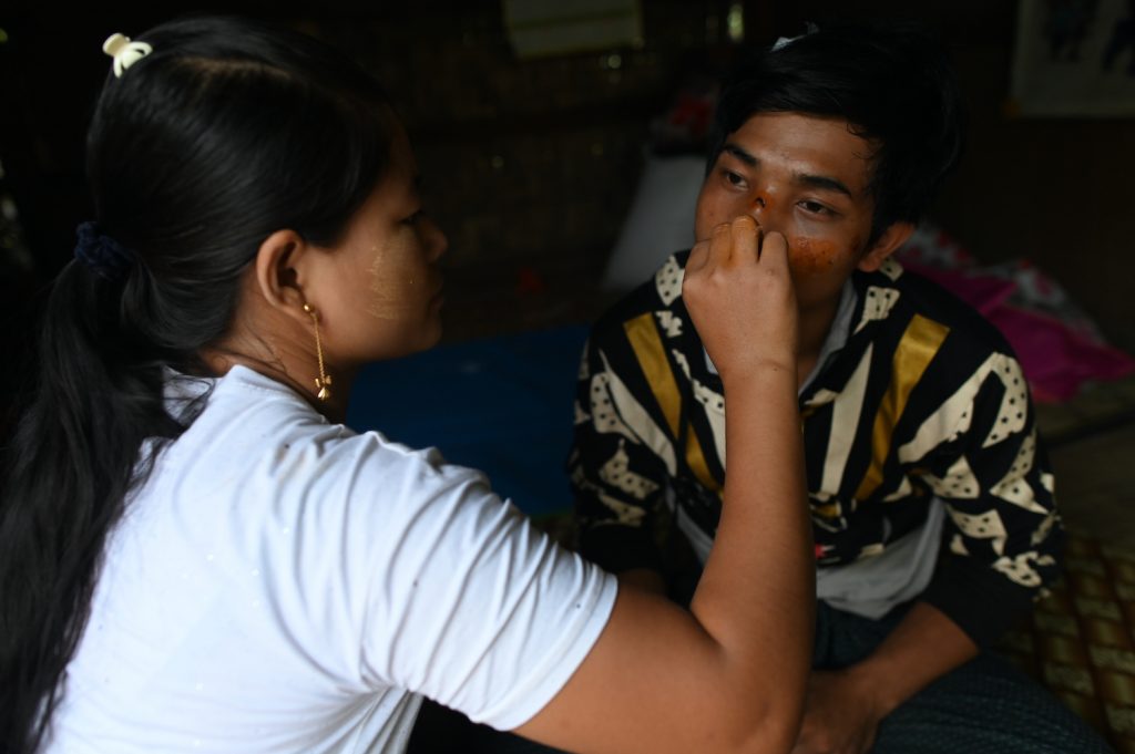 Ma Pan Ei Phyu treats her husband Sai Ko, who survived the deadly landslide. (AFP)