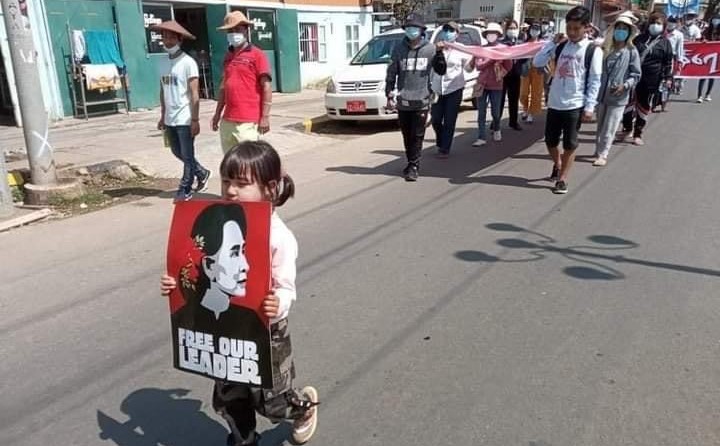 Su Htet Wine, 5, leads a protest march while holding a poster of Daw Aung San Suu Kyi in Mogok. (Supplied)